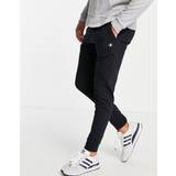 Champion small logo tracksuit bottoms in black-Navy