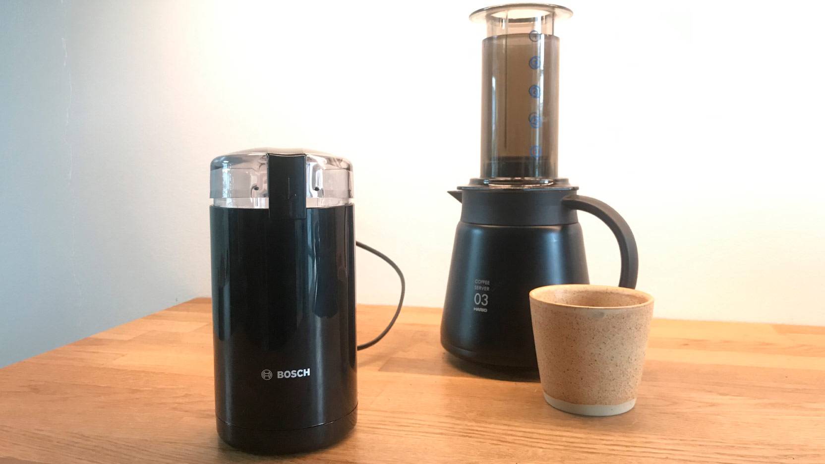 Image of Bosch TSM6A013 coffee mill on kitchen counter with Hario AeroPress in the background